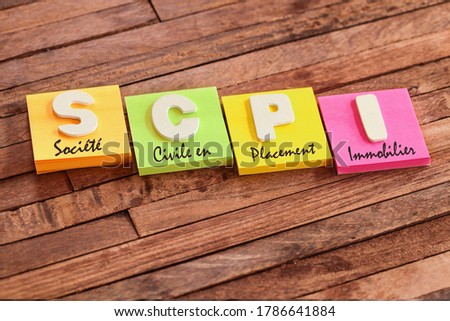 Colorful square papers with wooden white letters for the French acronym SCPI means Real estate Investment Company
