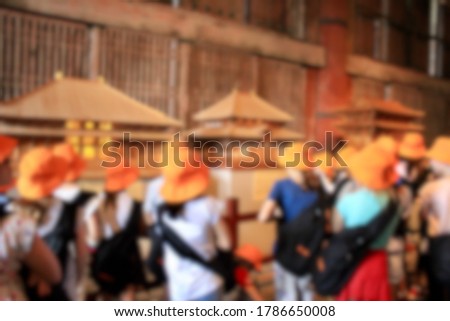 Blur picture  of children in orange hat who took a tour with their friends at the temple in Japan