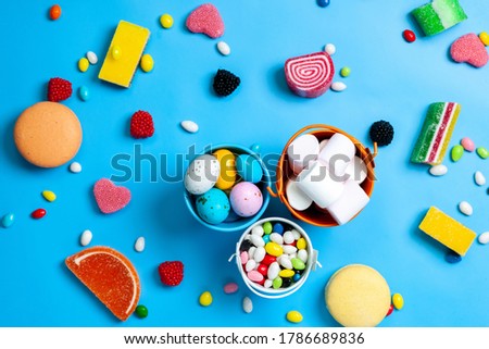 a top view cakes and candies multicolored cookies macarons isolated on the blue background marmelade sweet biscuit