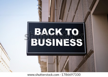 BACK TO BUSINESS. Sales, service and tourism industry concept. Black advertising sign on the wall of the building