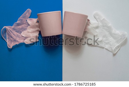 cheers with a cup of coffee. The picture shows coffee cups and the gloves on blue and  background.