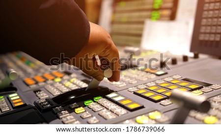 Hands on dissolve of Switcher buttons in studio TV station, Audio and Video Production Switcher of Television Broadcast.