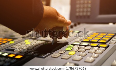 Hands on dissolve of Switcher buttons in studio TV station, Audio and Video Production Switcher of Television Broadcast.