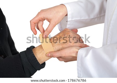 Picture of doctor's hand giving an adhesive plaster for an elderly hand