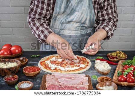 Pizza preparation with chef hands. Pizza making process decorating pizza
