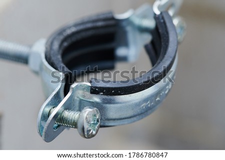 The clamp is plumbing, with a rubber gasket installed in a real situation. Screws, bolt, steel, rubberized, reliable during renovation in the apartment