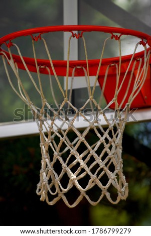 This is a photo of a basketball net, the net is aged and starting to fade, the rim is a little rusty, and the colors are vivid.