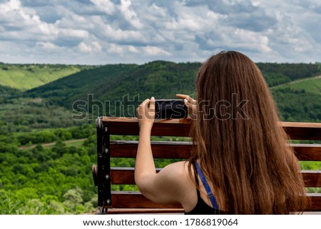 Girl and a beautiful view with a bench on the canyon.
