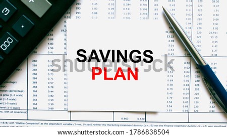 Work smarter text Savings Plan on white sheet with pen, calculator and tables