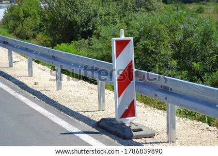 Red and white road sign that war drivers that the road is under construction