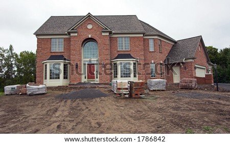 Color DSLR picture of a new, brick, executive colonial style home in a suburban subdivision.  Horizontal orientation with copy space for text.