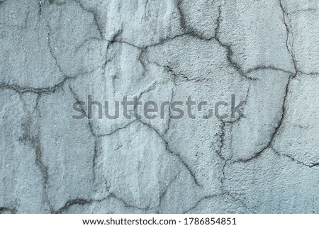 Gray cracked concrete wall. Background from a gray wall with cracks