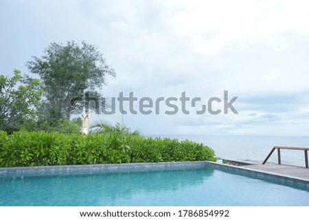 Swimming pool and surrounding garden and terrace. Sign says "Private Area" in Thai.