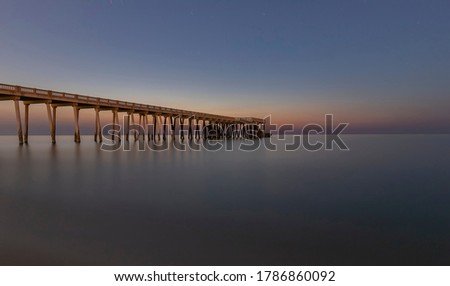 Pier going into the sea against the background of the starry sky
