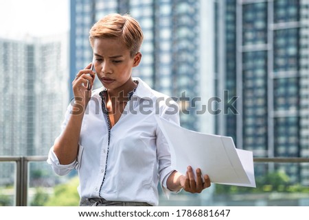 Business woman arguing on phone outside office building stock photo