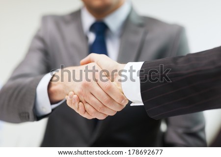 businesss and office concept - two businessmen shaking hands in office Royalty-Free Stock Photo #178692677