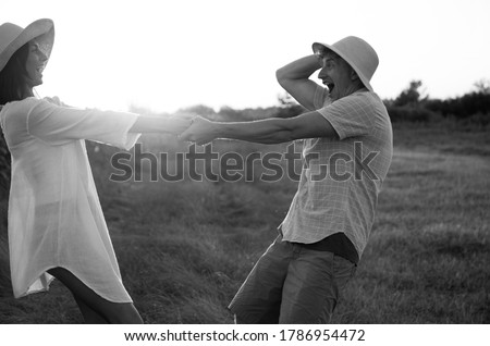 Young couple in love walking in the park holding flowers
