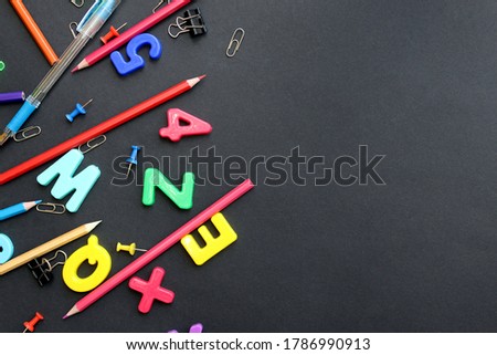 english letters and stationery for school on black background with place for text