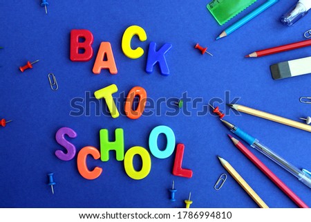 lettering back to school on bright blue background with stationery