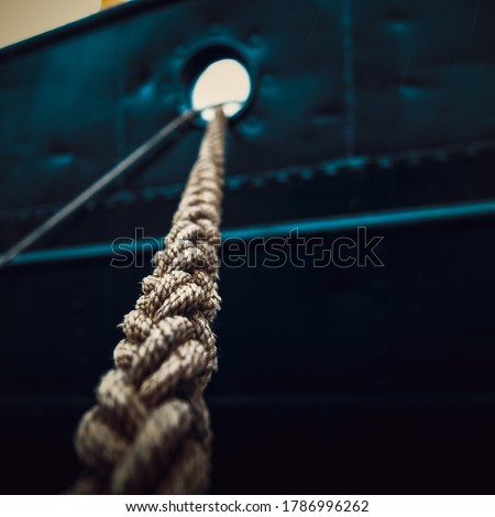 Rope that tied the ship close-up on the background of the ship's side.