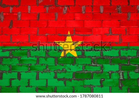 The national flag of Burkino Faso
 painted on a wall of sibit blocks with cement . The symbol of the country.