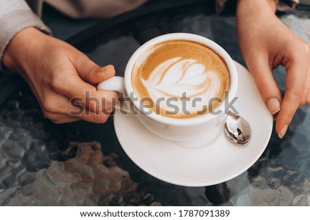 Young woman holding hot cup of coffee