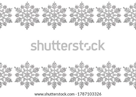 frame of Christmas decor in the form of silver snowflakes on a white background. new year concept, top view, flat lay.