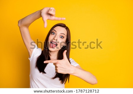 Portrait of carefree careless playful girl make fingers camera photographing show tongue-out wear style stylish trendy clothes isolated over bright shine color background