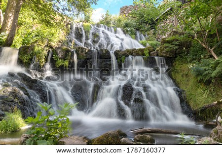 beautiful magical waterfall in Rottle Sweden  with lush vegetation around. With long exposure technic the water seem to be blur or in motion