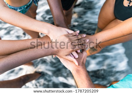 Multiethnic  people with black, latin, caucasian and asian hands.  Friends with stack of hands showing unity and teamwork. tolerance, teamwork and anti racism concept. Image