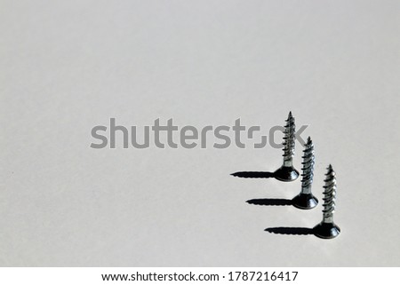 Three upturned screws with 90 degree shadows and white background