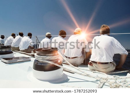 Rear view of sailing crew with lens flare Royalty-Free Stock Photo #1787252093