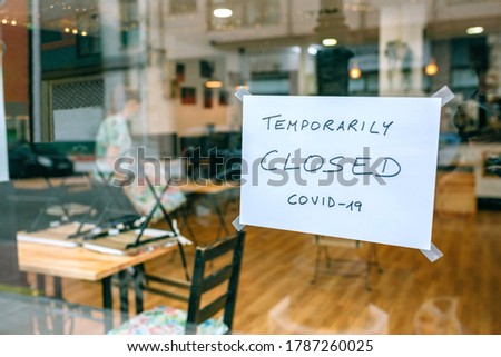 Coffee shop closed by covid-19 with workers picking up and cleaning inside