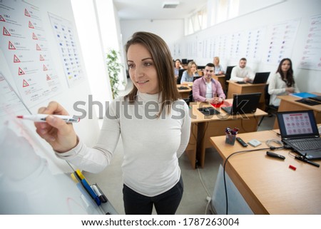 Driving instructor drawing about traffic rules on the whiteboard in the classroom