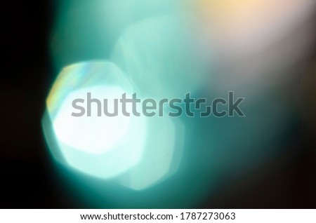 Turquoise bokeh on a dark background. Blur, defocusing. Template. Backdrop. Blue shades. Rounds.