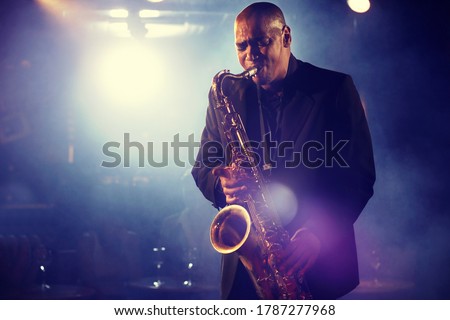 Man Playing Saxophone on Stage Royalty-Free Stock Photo #1787277968