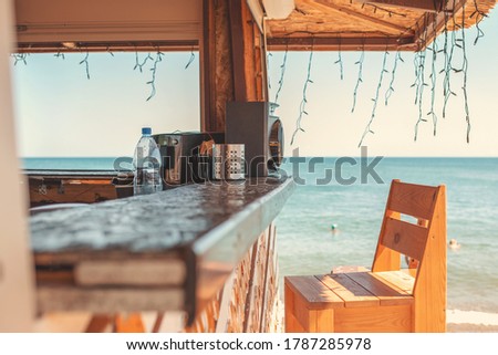 Sunny. An empty bar counter and an empty chair against the background of the beach and the sea. Vacation and summer