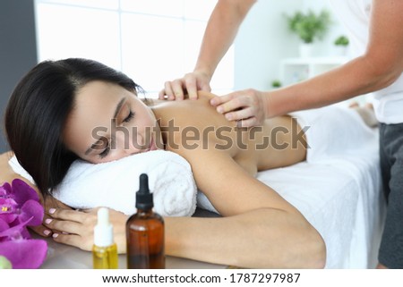 Woman in spa is being massaged by masseur. Classic relaxing relaxing massages in a beauty salon
