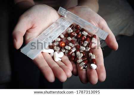 Daily doze of drugs for Cystic Fibrosis patient includes pancreatic enzymes, nebulizer antibiotics and vitamins.  Royalty-Free Stock Photo #1787313095