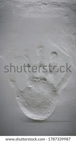 Child hand printed on white wall