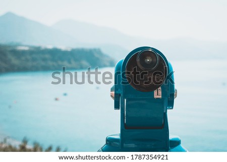 Blue binoculars looking out onto a beach