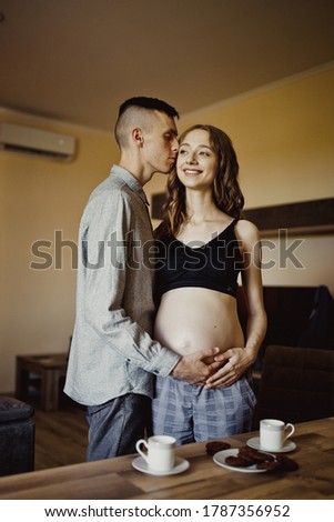 Young pregnant woman with her family at home