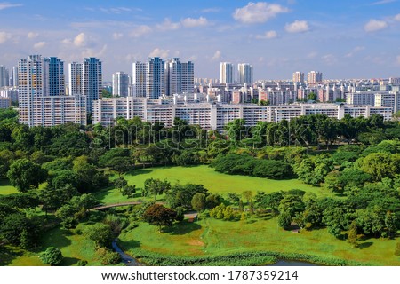 Clear view of skyline of high rise public housing on bright sunny day, with lush green public park in foreground. Beautiful day with blue sky and clouds, SIngapore Royalty-Free Stock Photo #1787359214