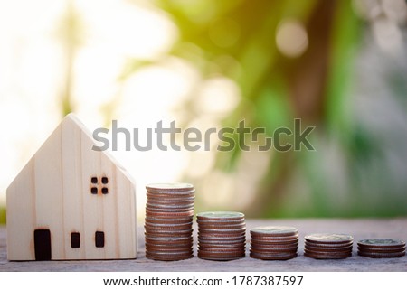 Selective focus of coins stack for saving money to buy a home, property with small house and bokeh background. Business, Financial, Investment, Wealth, health and saving plan for the future education.