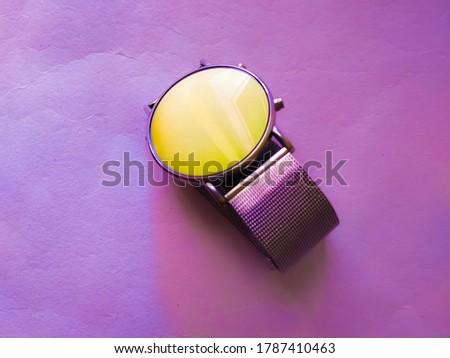 blurry photo of wristwatch with purple gradient background