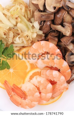 Shrimps and champignons with lemon slices.