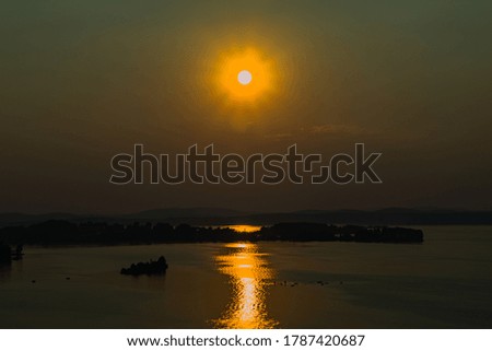 bright sunset by the lake with a small island