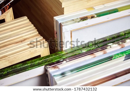 Canvas prints, stack of colorful photos with gallery wrapping method of canvas stretching on wooden stretcher bars. Samples of stretched photo canvases. Staple mount, back view