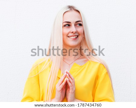 Close up portrait of pretty confident thoughtful woman, holding hand near the face, looking seriously up, standing over white background with copy space