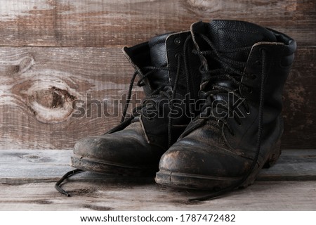 Old dirty shoes boots ankle boots on a wooden background with copy space.